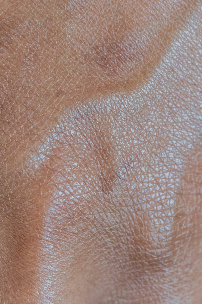 Close-up of light brown skin with a network of fine lines and small pores.