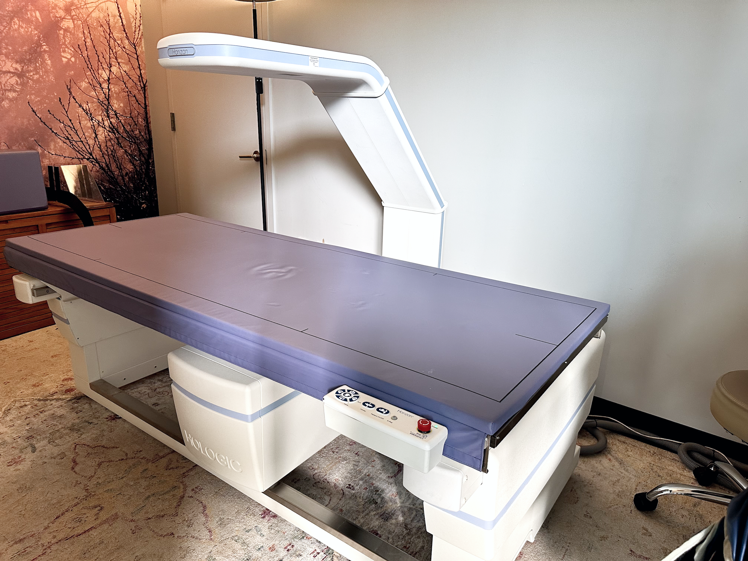MRI/CT imaging table with Horizon gantry in a clinical room, light blue padding.